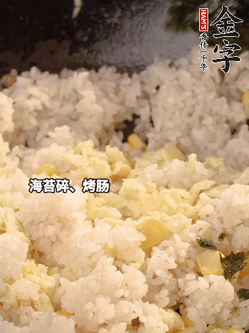 剩米飯下鍋炒散，依次下玉米粒、雞蛋、烤腸、海苔碎翻炒均勻。