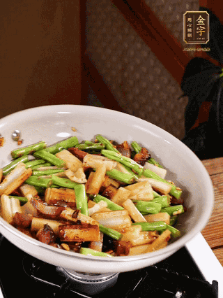 油熱下蒜末、干辣椒、醬肉煸炒出香味，依次下藕條、豆角翻炒均勻